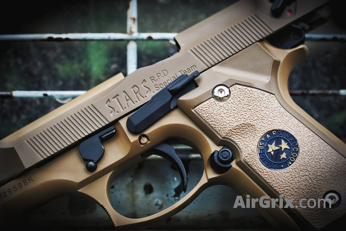 WE M9 Biohazard 20th Anniversary Tan GBB Pistol, left frame angled close-up showing STARS R.P.D. engraving and trigger